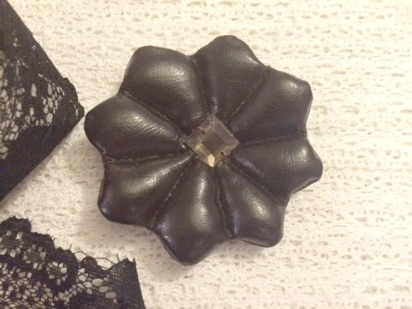 Broche de cuero marrón con diamantes de imitación cuadrados.