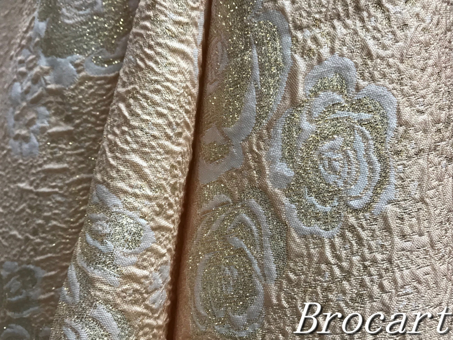 tissu brocart saumon, sublimé par des motifs fleurs blanches et des touches dorées, pour des créations d'exception"