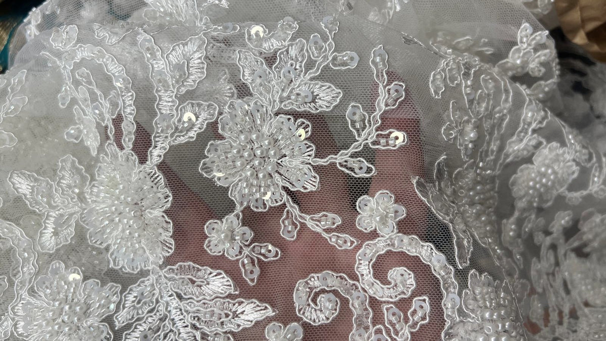 FR : Bord festonné du tulle blanc à motifs perlés. EN: Scalloped edge of white beaded floral tulle.