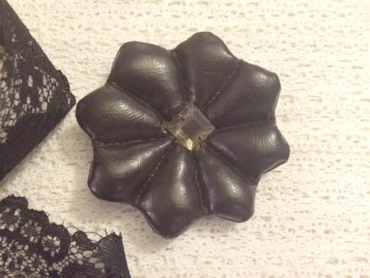 Broche de cuero marrón con diamantes de imitación cuadrados.