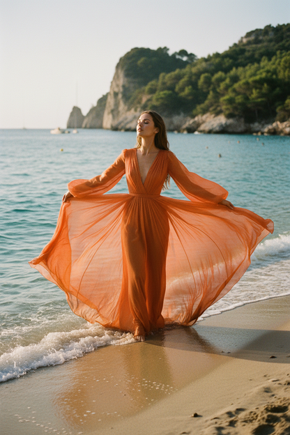 Femme en robe fluide mousseline de soie orange sur la plage – tissu haute couture