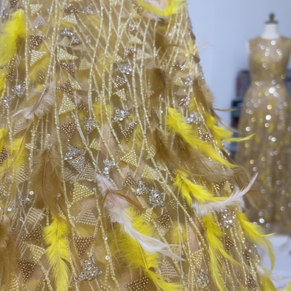 Macro détail perlage strass et plumes jaunes sur tulle doré haute couture