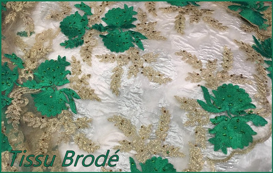 Couture Embroidered Fabric on Flesh Mesh Tulle with Emerald Green and Gold Floral Motifs.