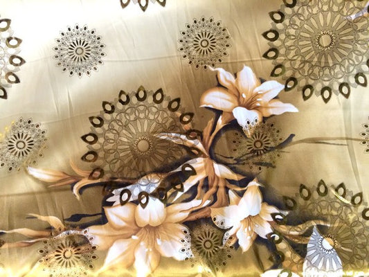 Tela de satén estampada de poliéster en color salmón con estampado de flores doradas.
